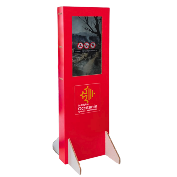 Red freestanding information kiosk with a display screen showing a nature photo and warning icons; La Région Occitanie logo at the bottom.